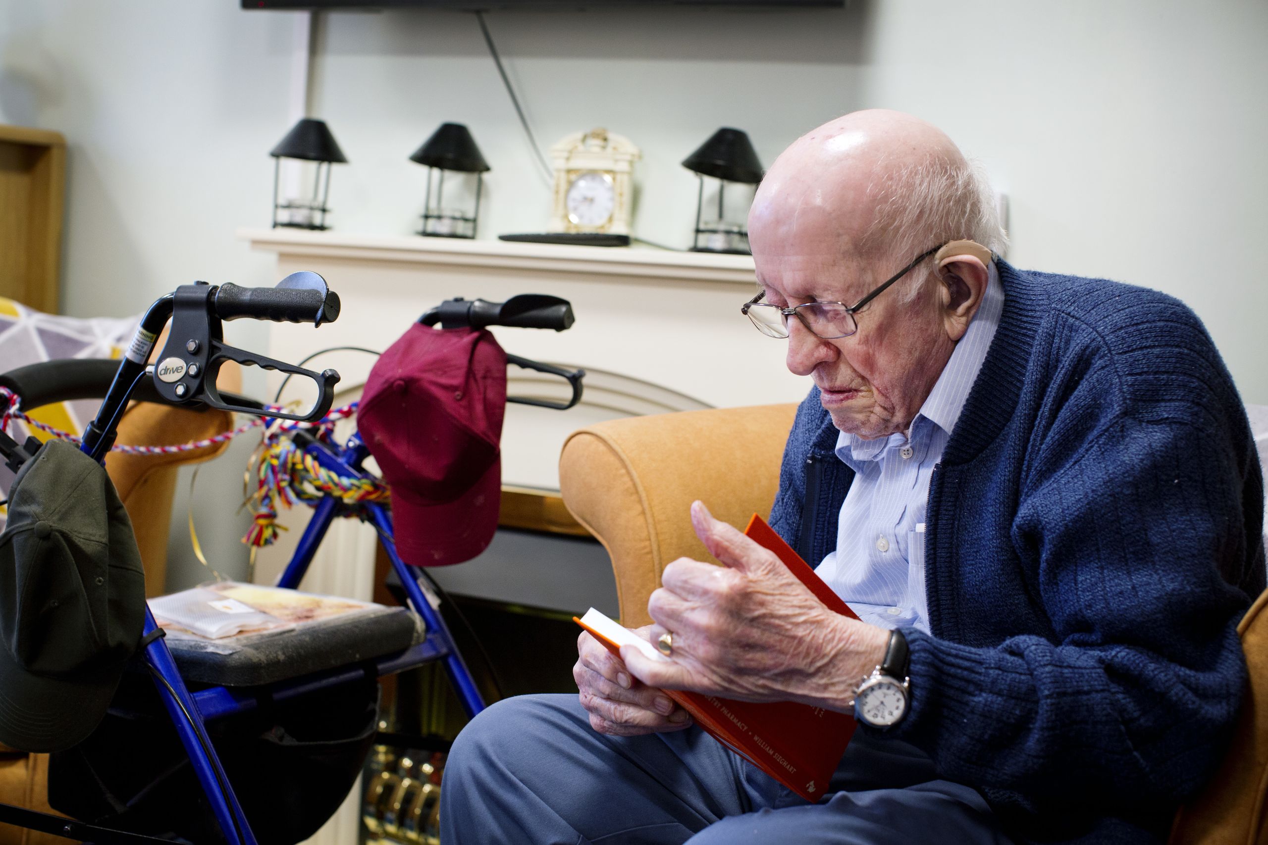 An elderly man reading The Poetry Pharmacy at Gregory House care home in Grantham
